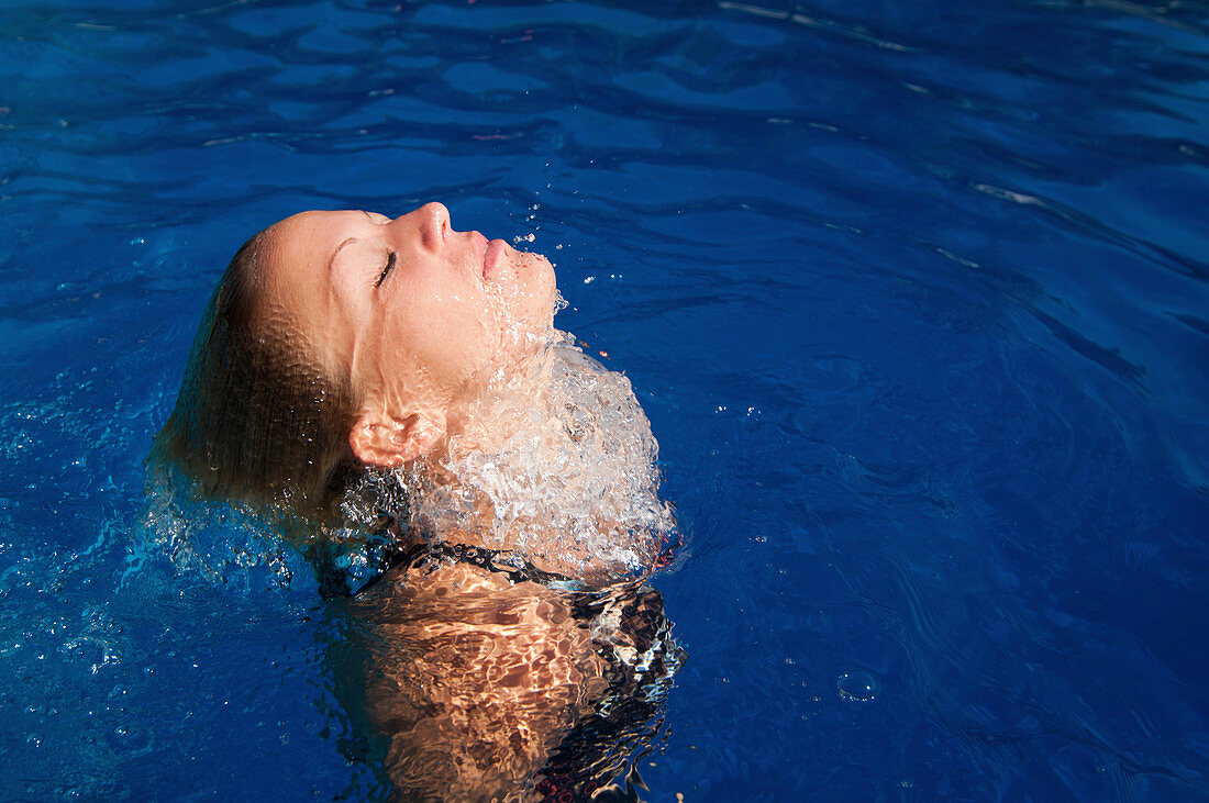 Woman surfacing from underwater