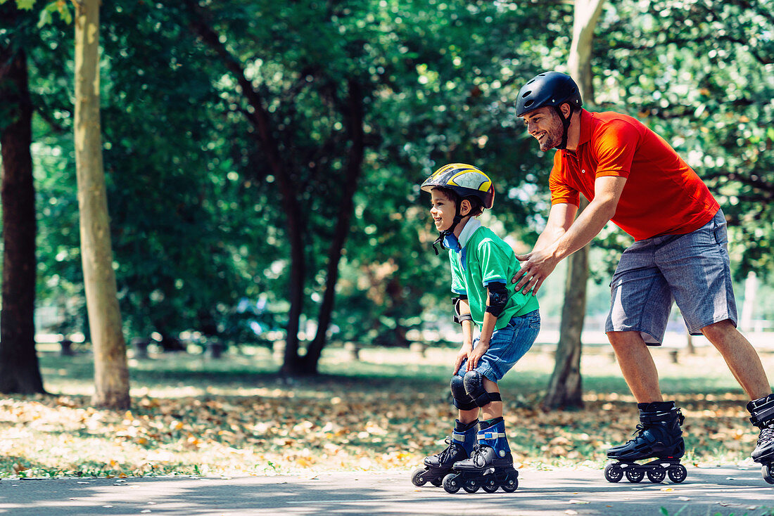 Father and son roller skating in park