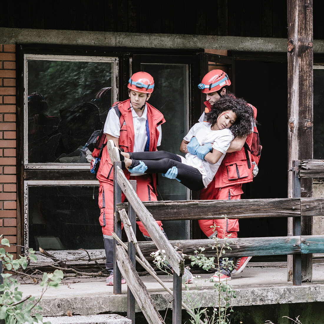 Rescue team evacuating woman from house