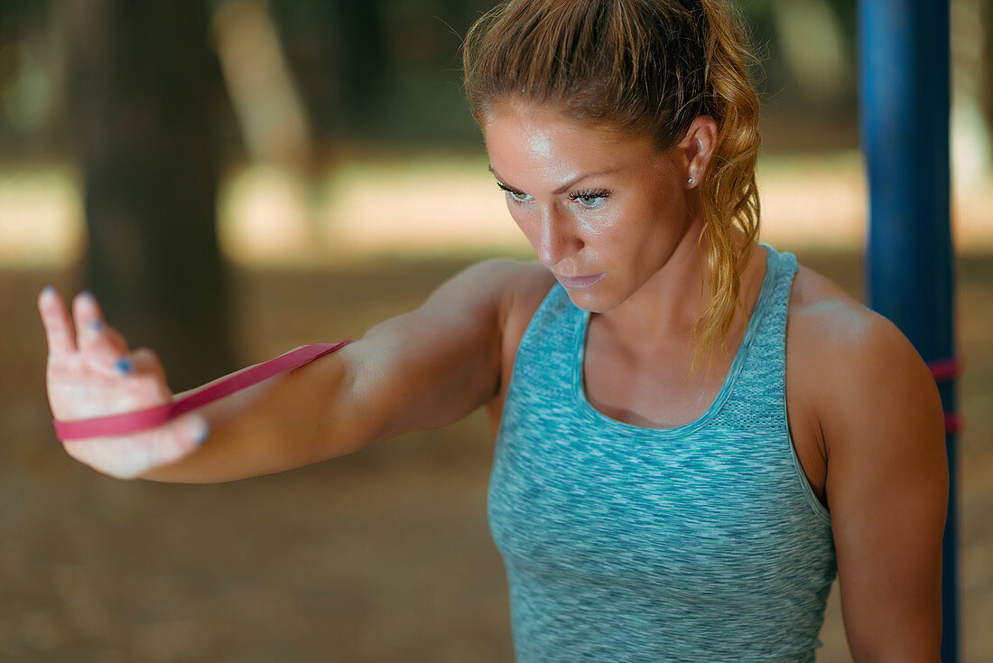 Woman exercising with elastic band outdoors