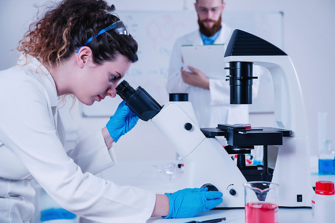 Scientist using microscope