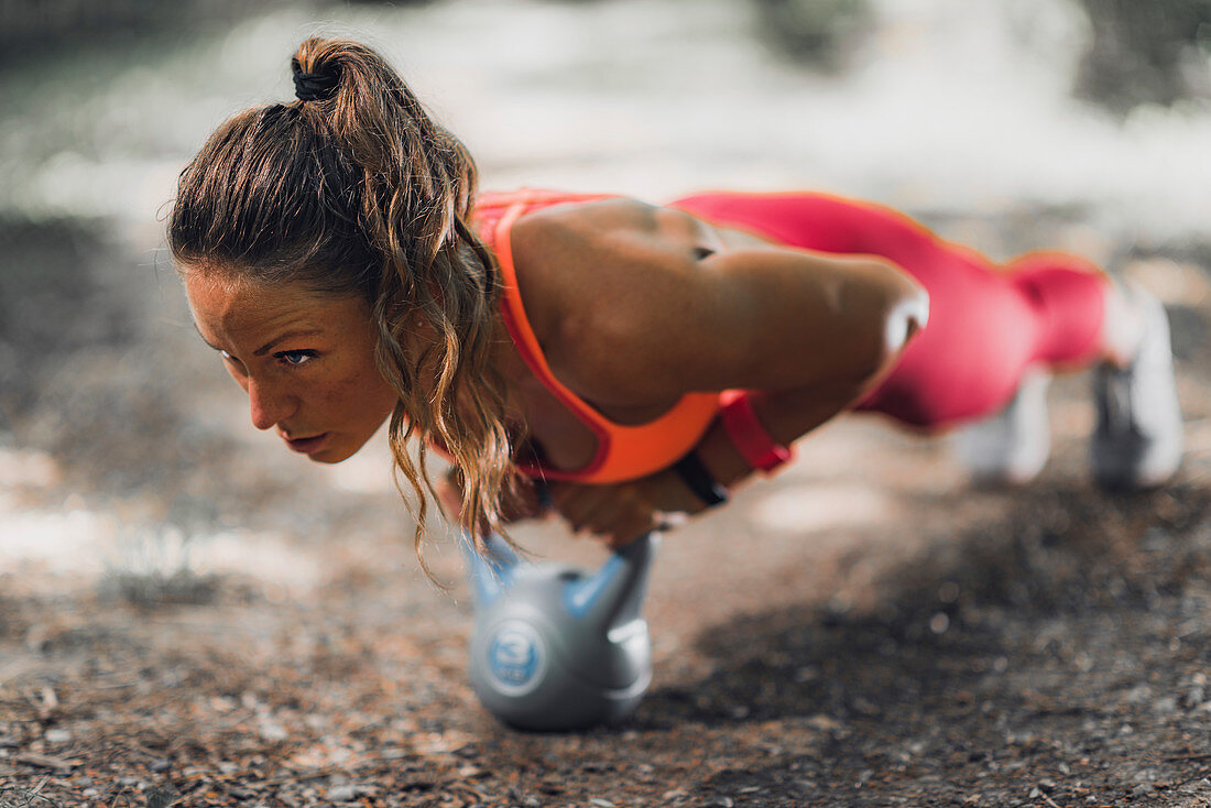 Woman exercising with kettlebell outdoors