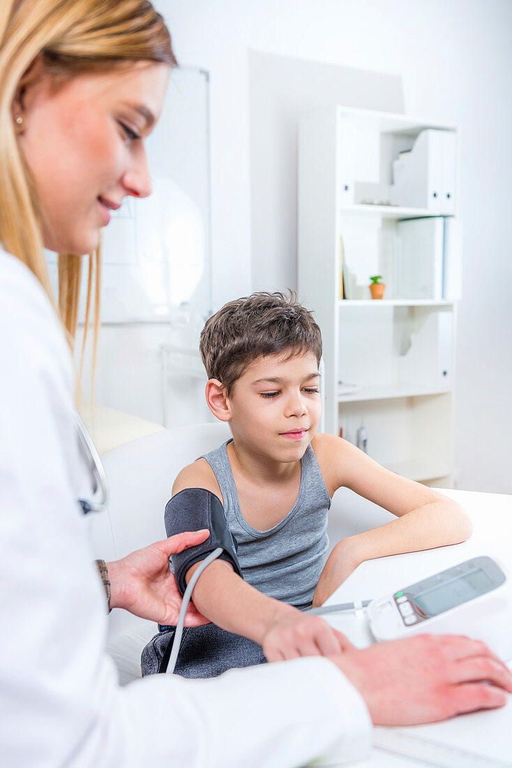 Paediatrician measuring boy's blood pressure