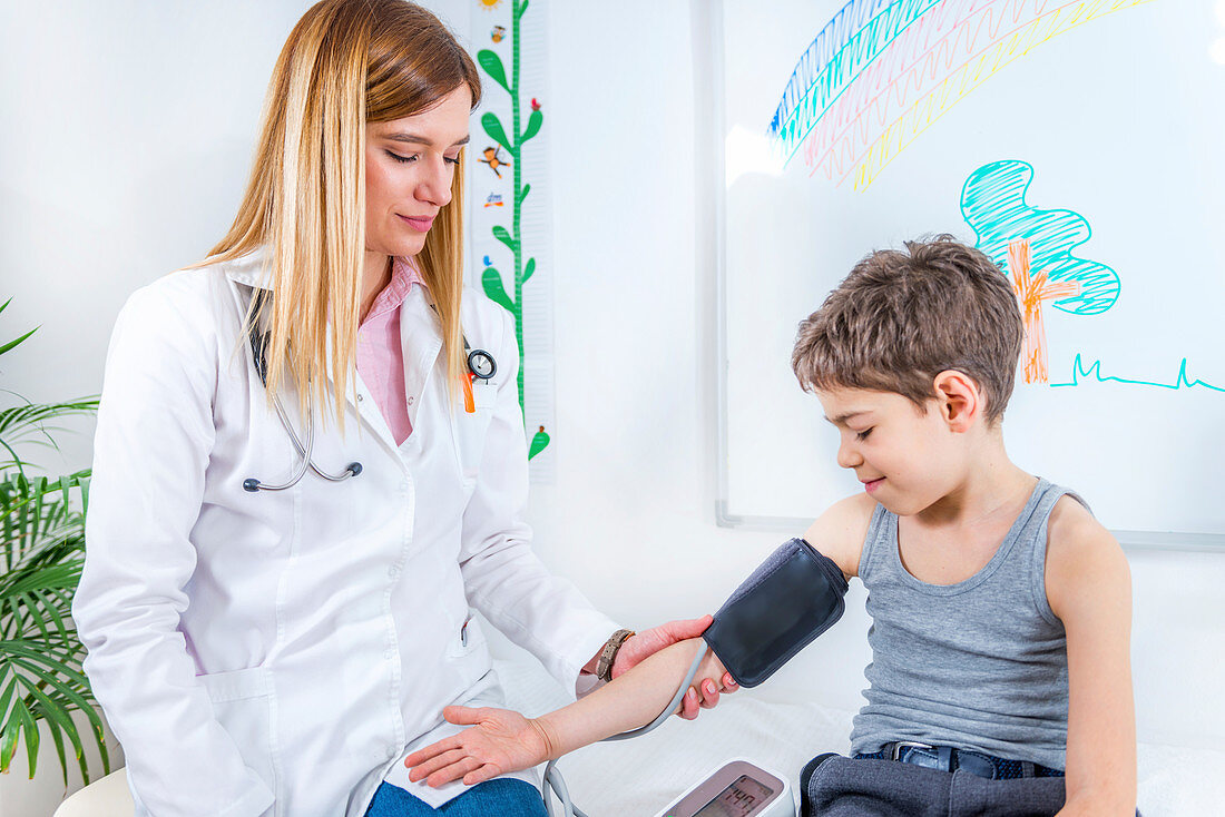 Paediatrician measuring boy's blood pressure
