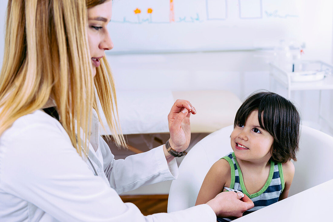 Paediatrician measuring boy's temperature