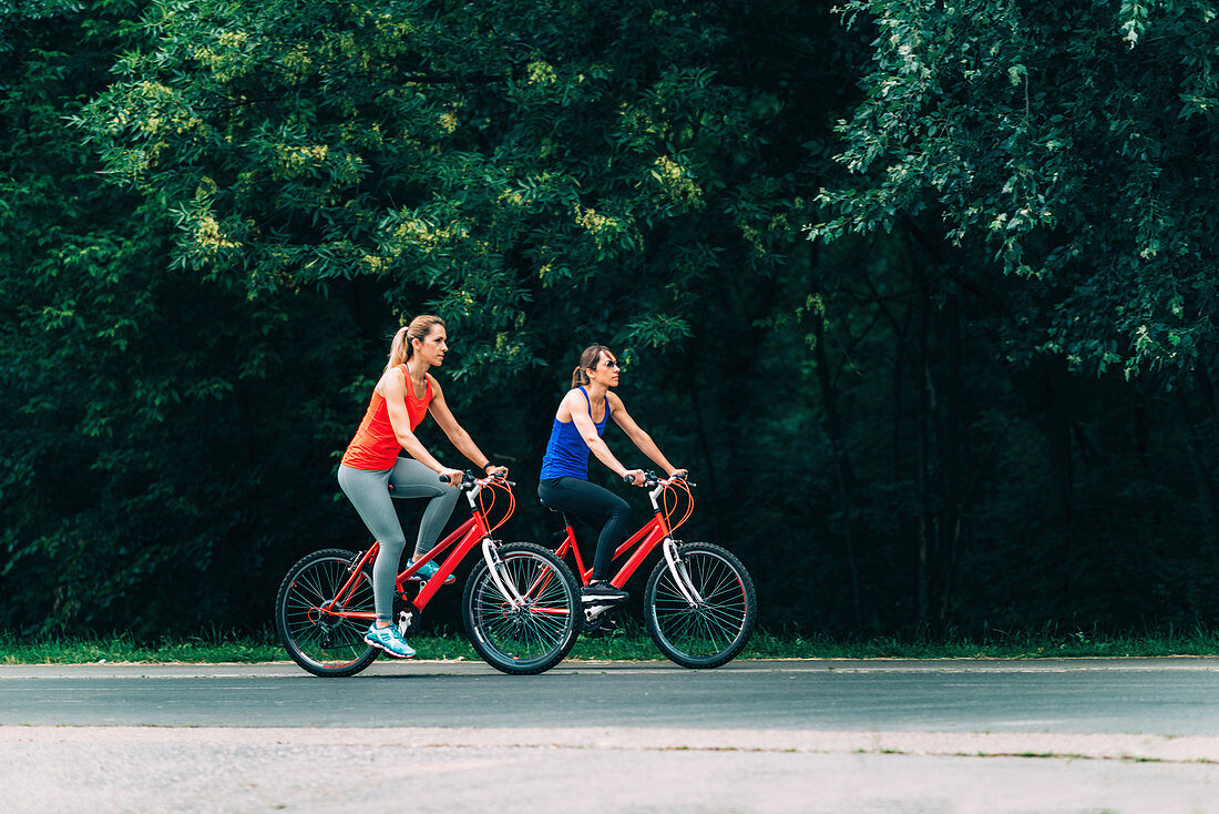 Two women cycling together