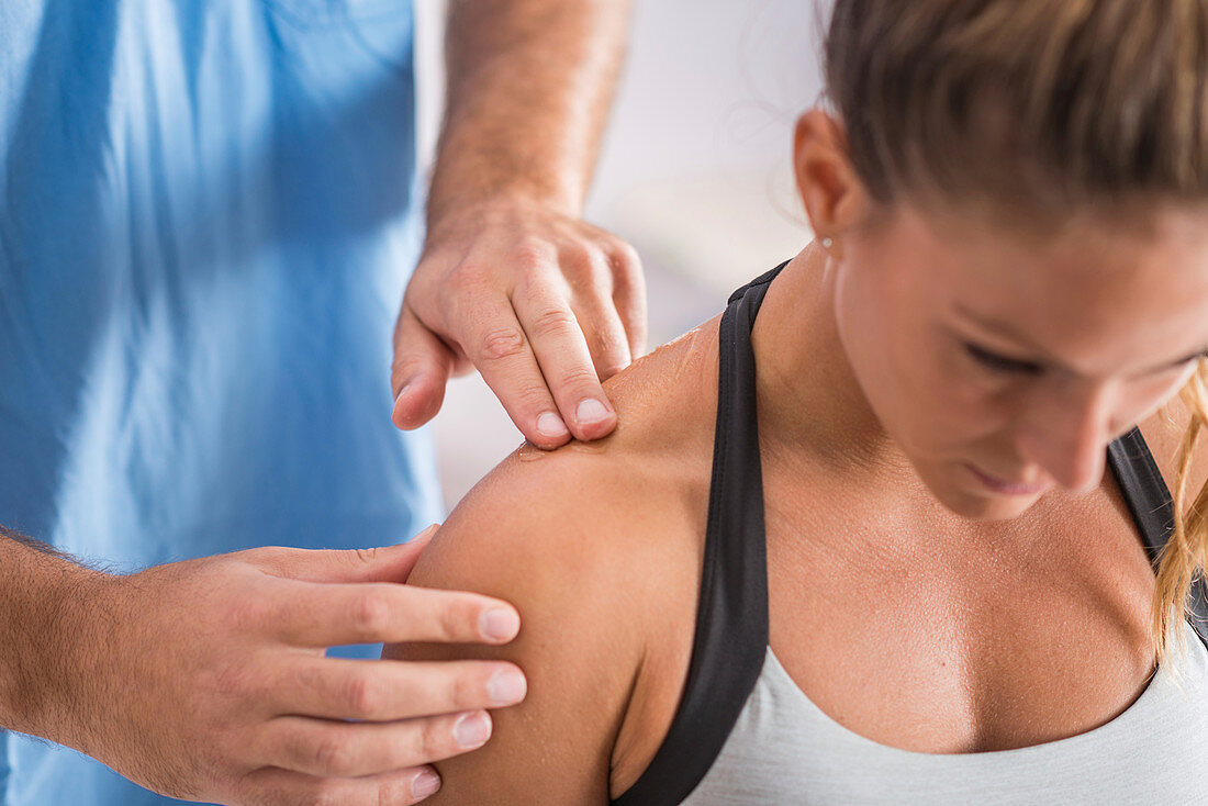 Physical therapist treating trapezius muscle