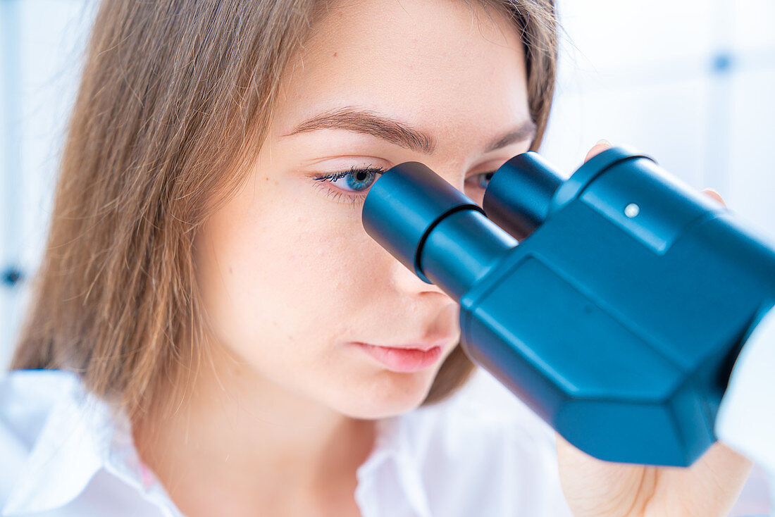 Researcher using microscope