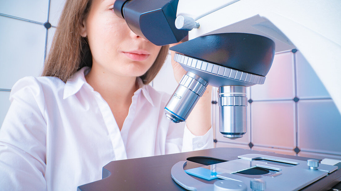 Researcher using microscope