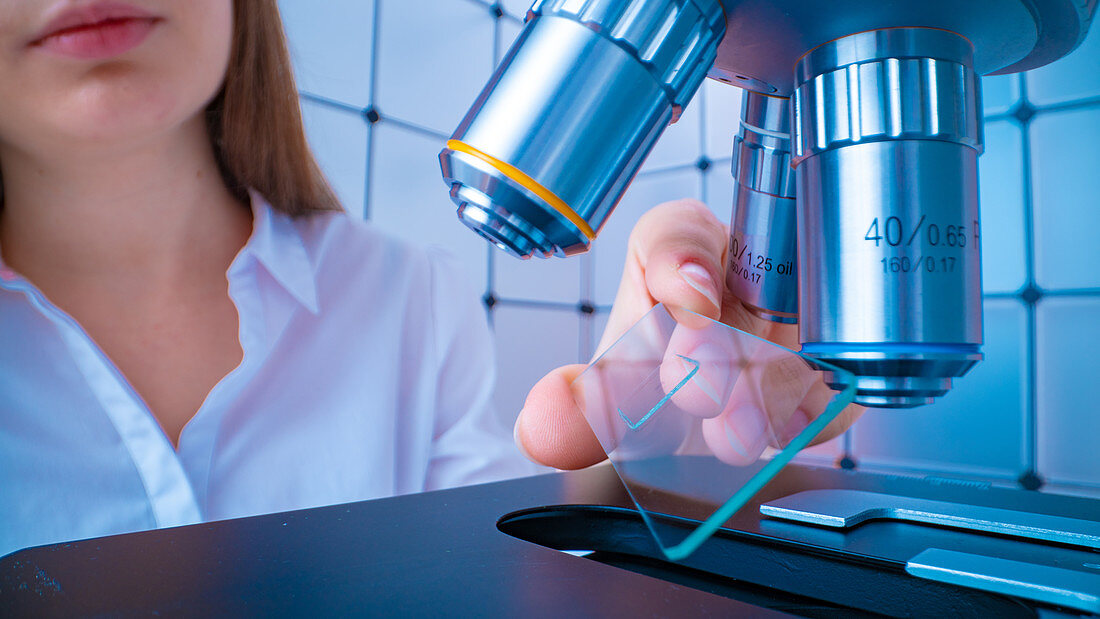 Researcher using microscope