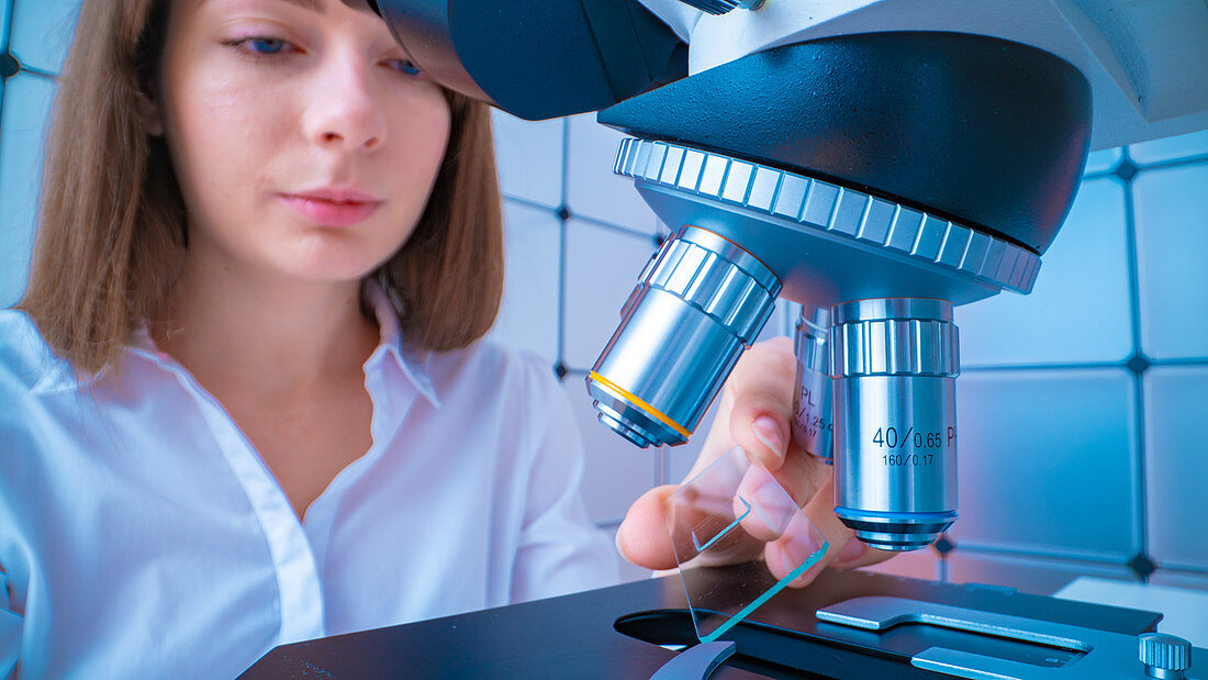 Researcher using microscope