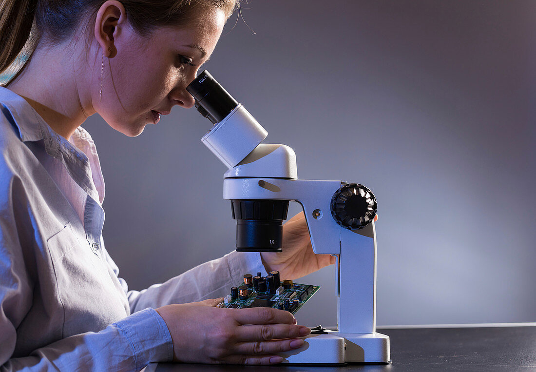 Technician examining circuit board