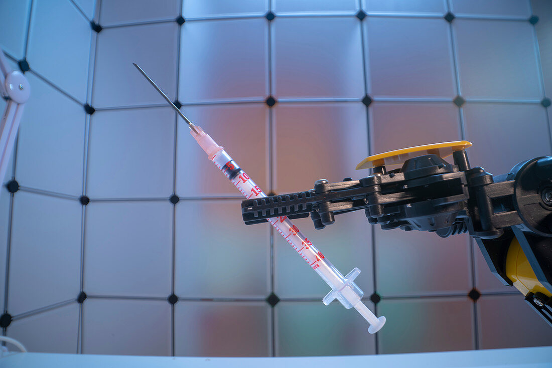 Robot arm holding syringe