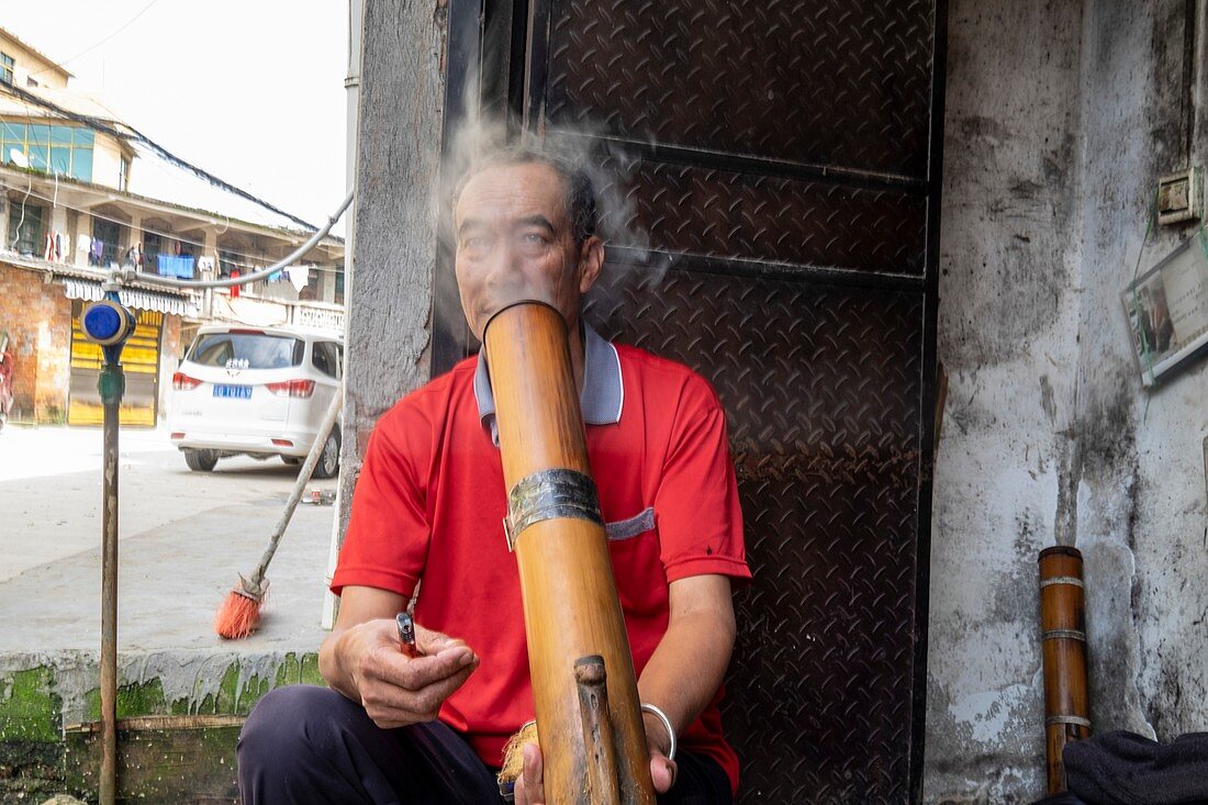 Man smoking water pipe, China