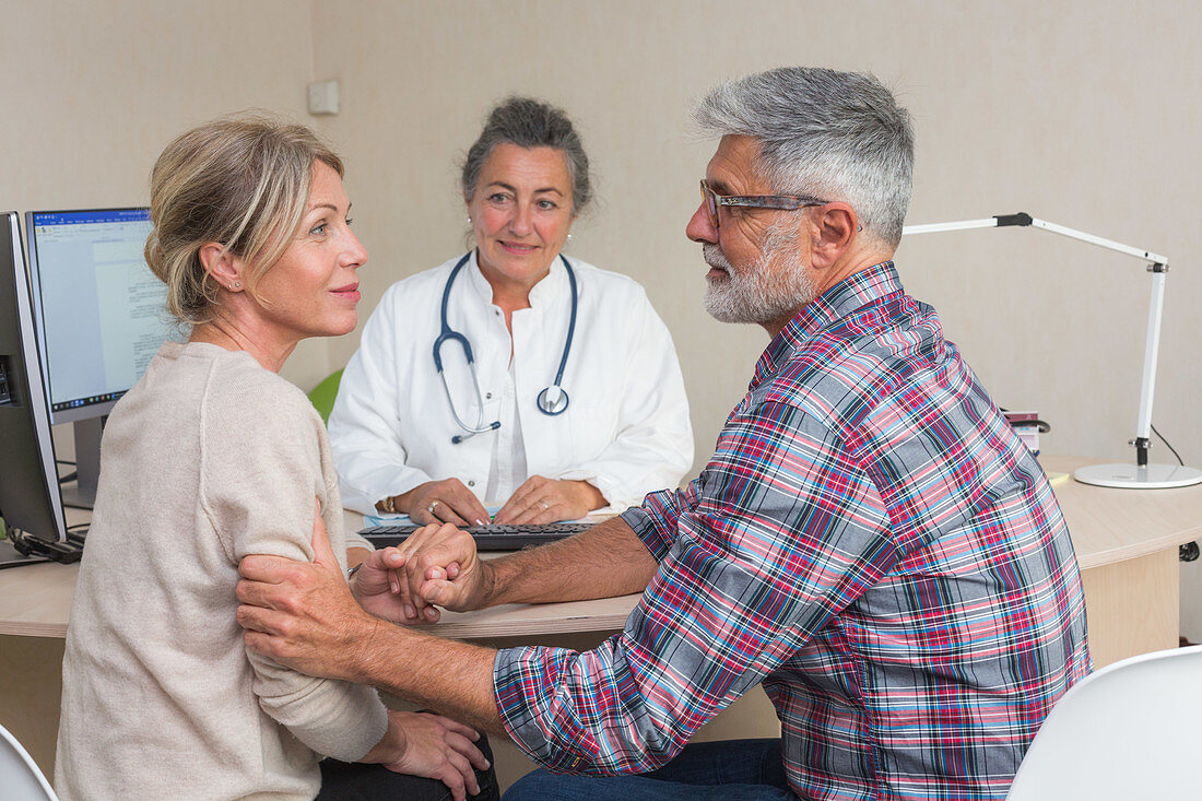Doctor discussing with a couple during consultation