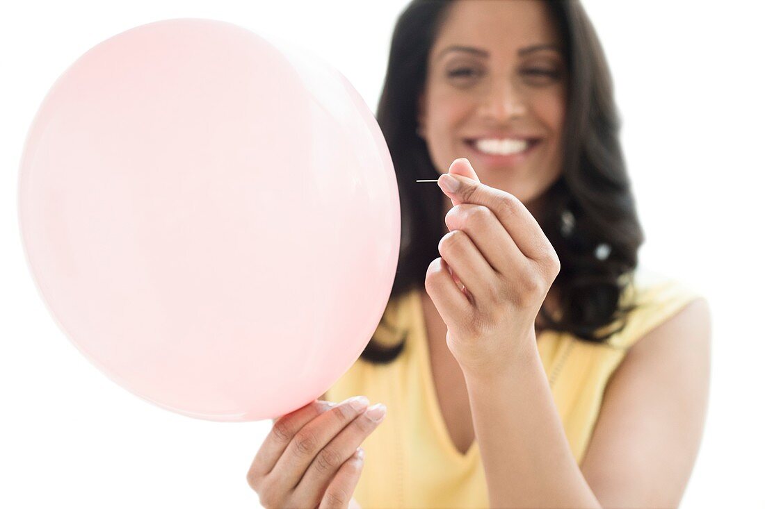 Woman popping a balloon