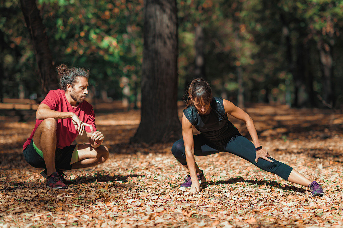 Young couple stretching after training in the park