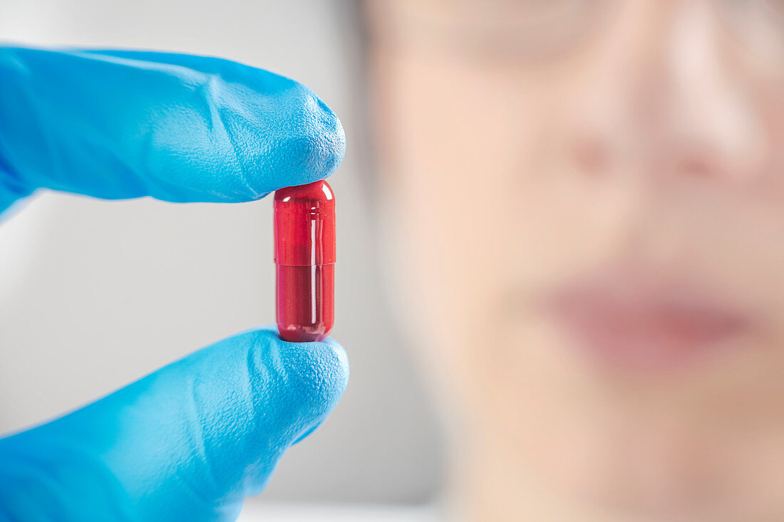 Scientist holding a red pill