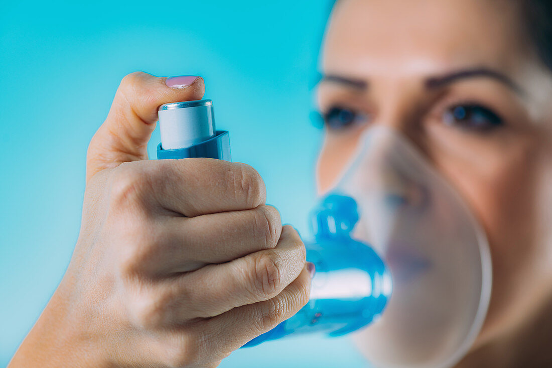 Woman using inhaler for asthma