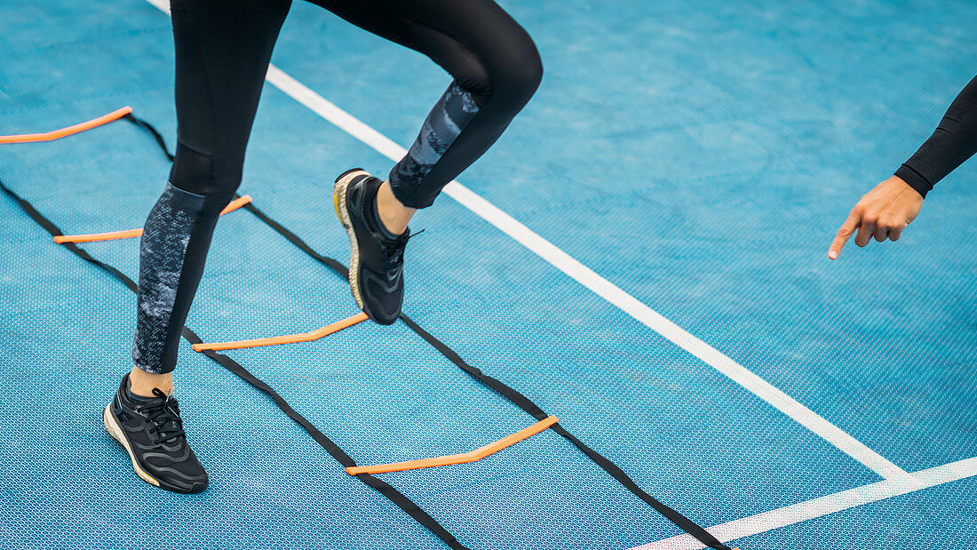 Young woman exercising with agility ladder