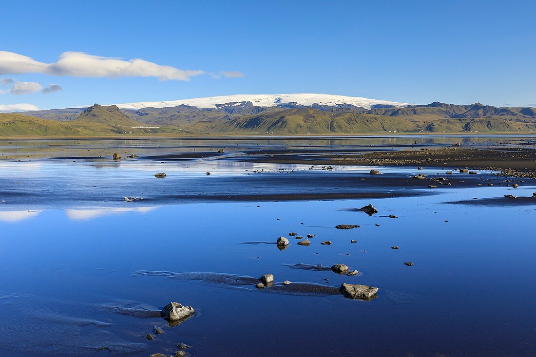 Myrdalsjoekull reflected in tidal flat,Iceland