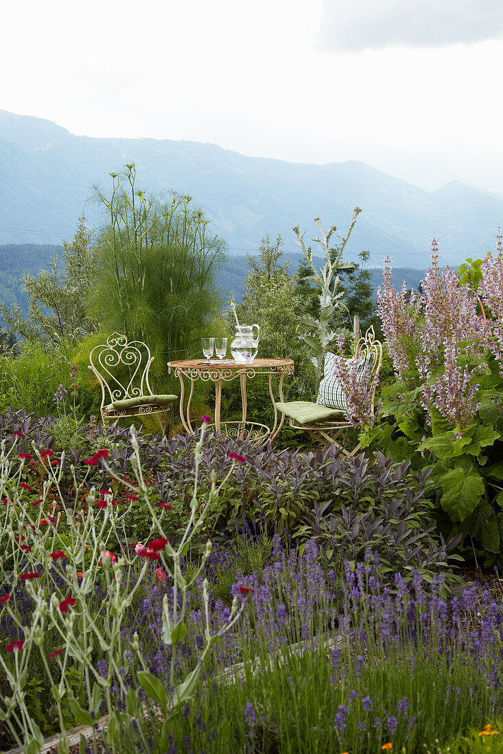 Idyllischer Sitzplatz mit verschnörkelten Gartenmöbeln