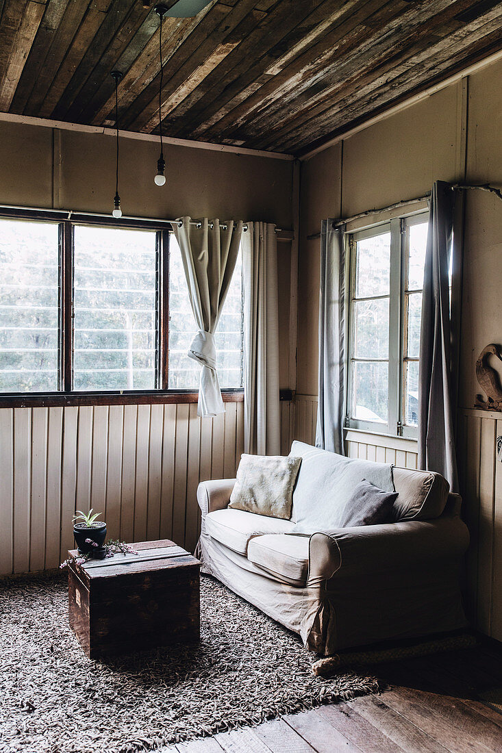 Living room in brown tones with rustic wooden ceiling