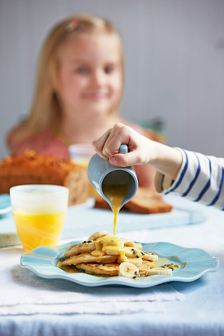 Coconut and banana pancakes pouring