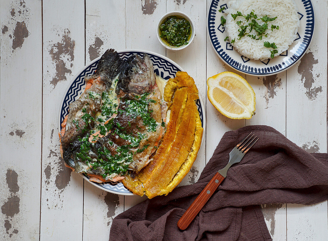 Colombian rucha al ajillo - river trout, served with a large, fried plantain, patacon and garlic sauce