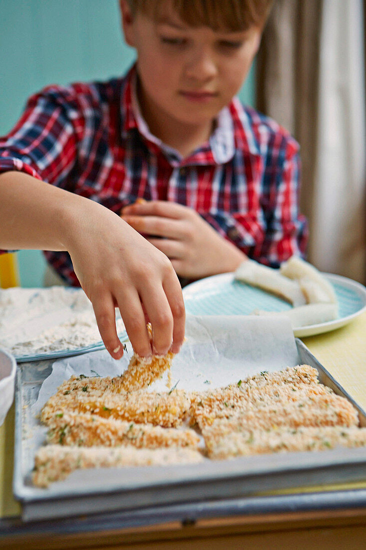 Boy preparing fish fingers