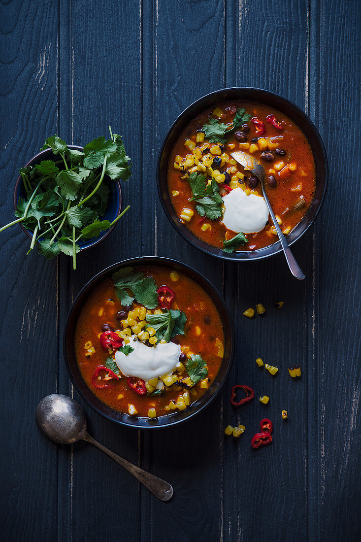 Spicy bean, corn and tomato chunky soup with chilli, cumin, coriander and sour cream