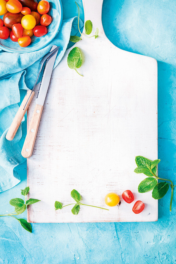 An arrangement of cocktail tomatoes and a chopping board