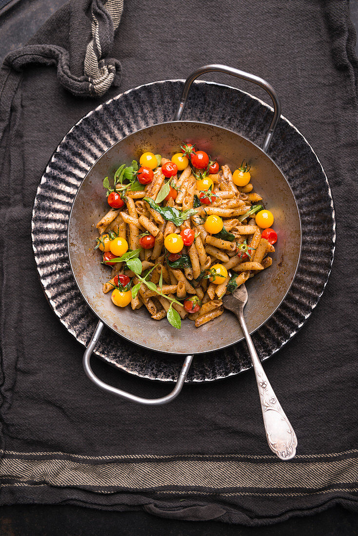 Fried vegan wholemeal pasta with pesto, fresh chard and colourful cocktail tomatoes