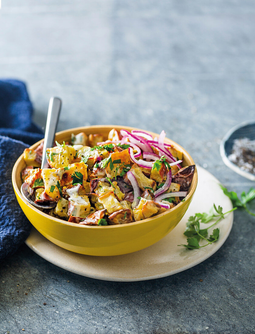 Kartoffelsalat aus gerösteten Süßkartoffeln mit roten Zwiebeln