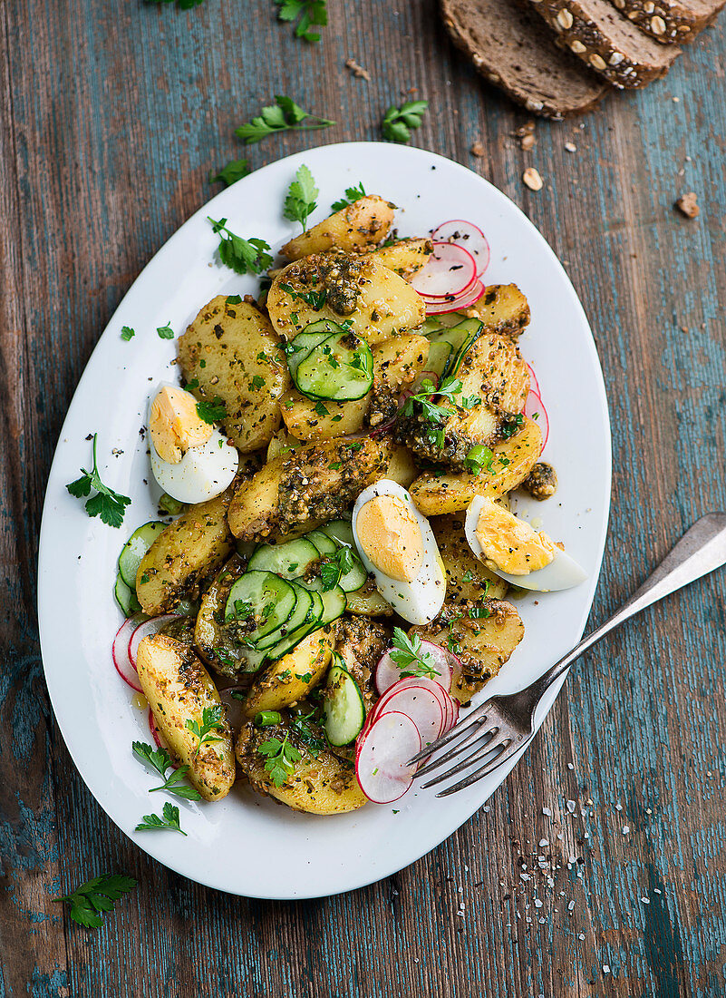 Potato and cucumber salad with radishes, egg and pesto