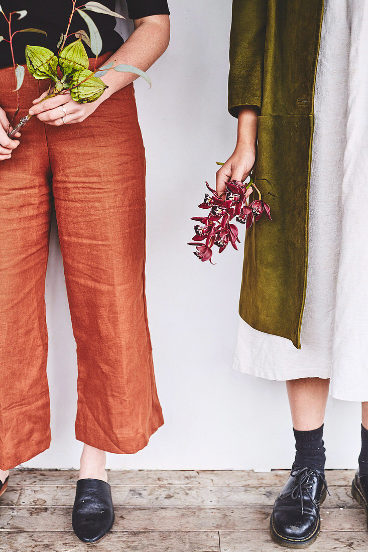 Two women with autumn branches in their hands