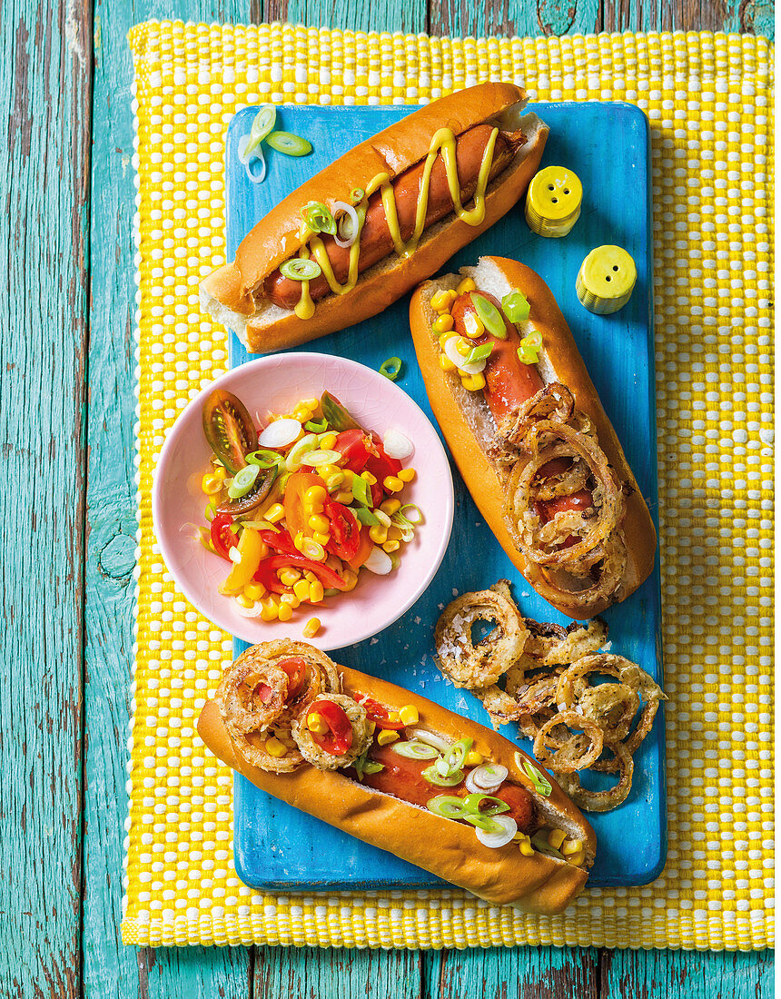 Hotdogs mit Maissalat und Zwiebeln