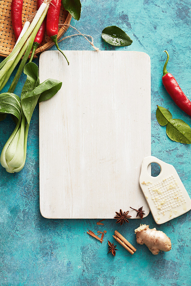 A still life with a cutting board, Asian vegetables and spices