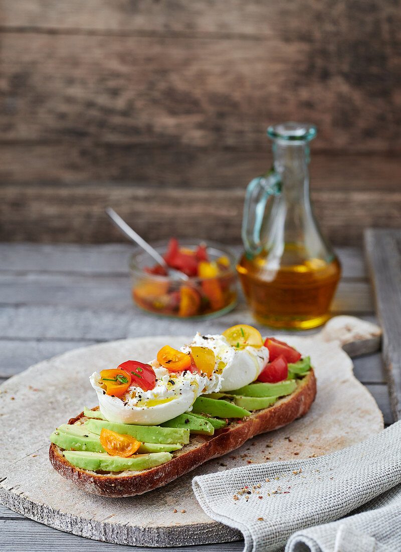 A baguette topped with avocado and burrata