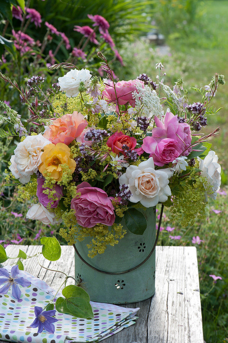 Country bouquet with roses, lady's mantle, oregano, candle, goat's rhombus and meadow chervil