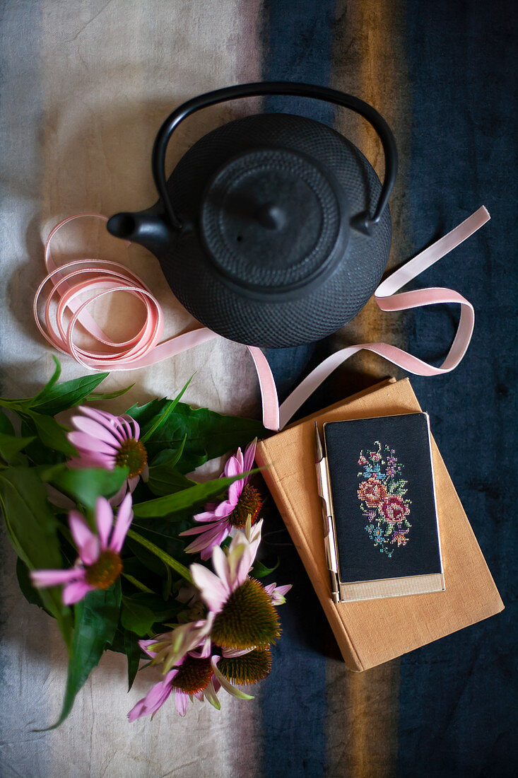 Schwarze Teekanne, Dekoband, Echinacea, Buch und Handyhülle mit Kreuzstich