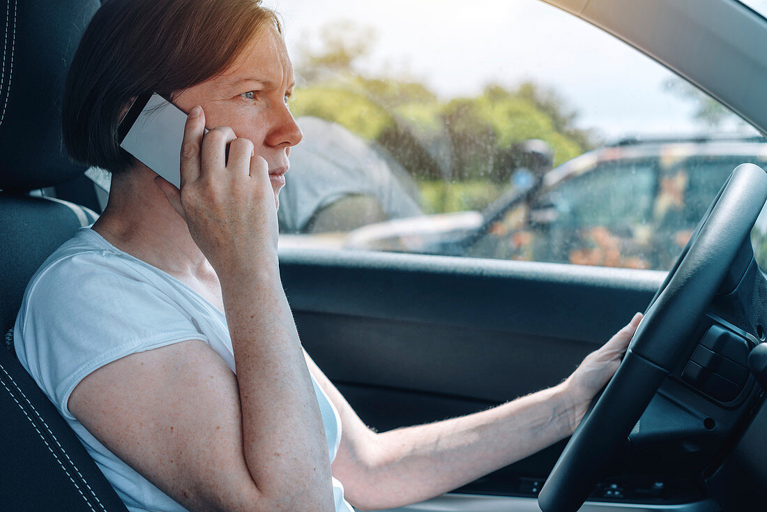 Woman driving car and using phone
