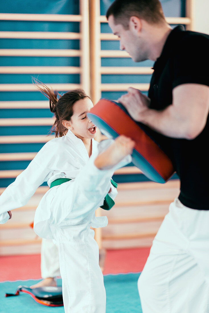 Taekwondo instructor working with girl