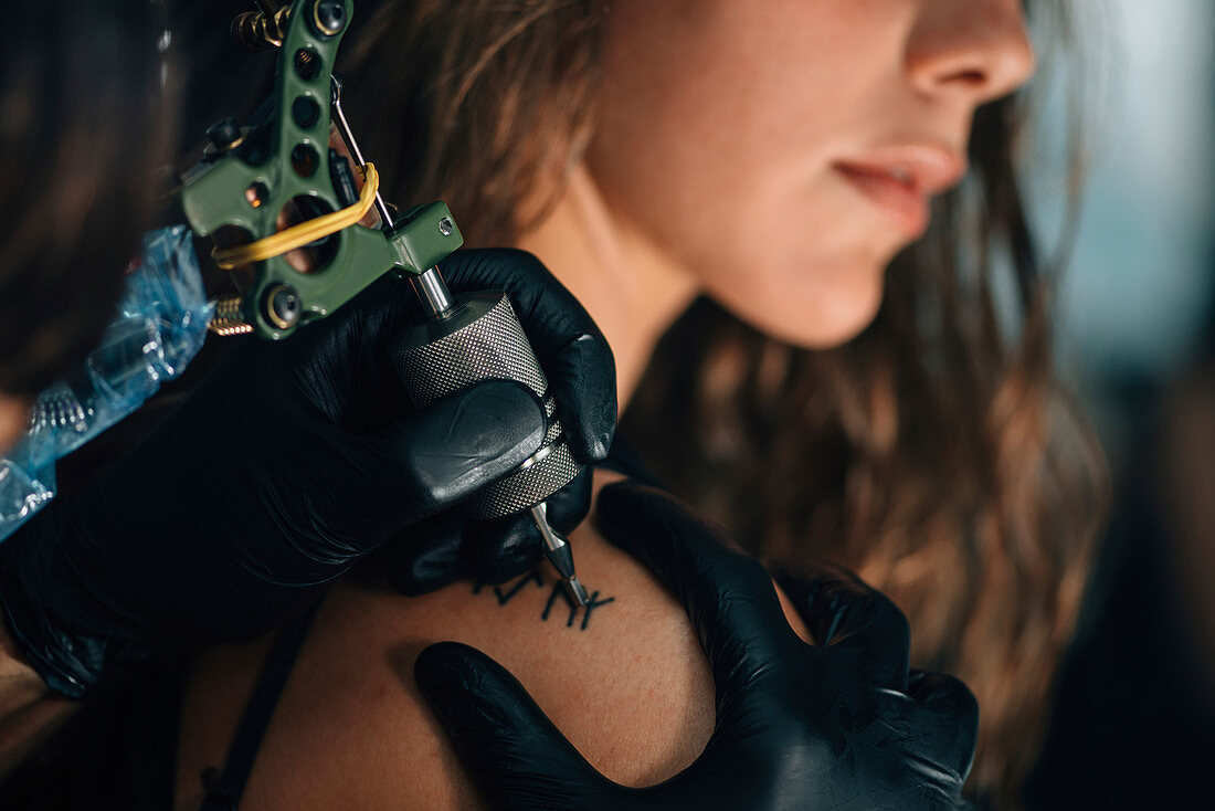 Woman getting a shoulder tattoo