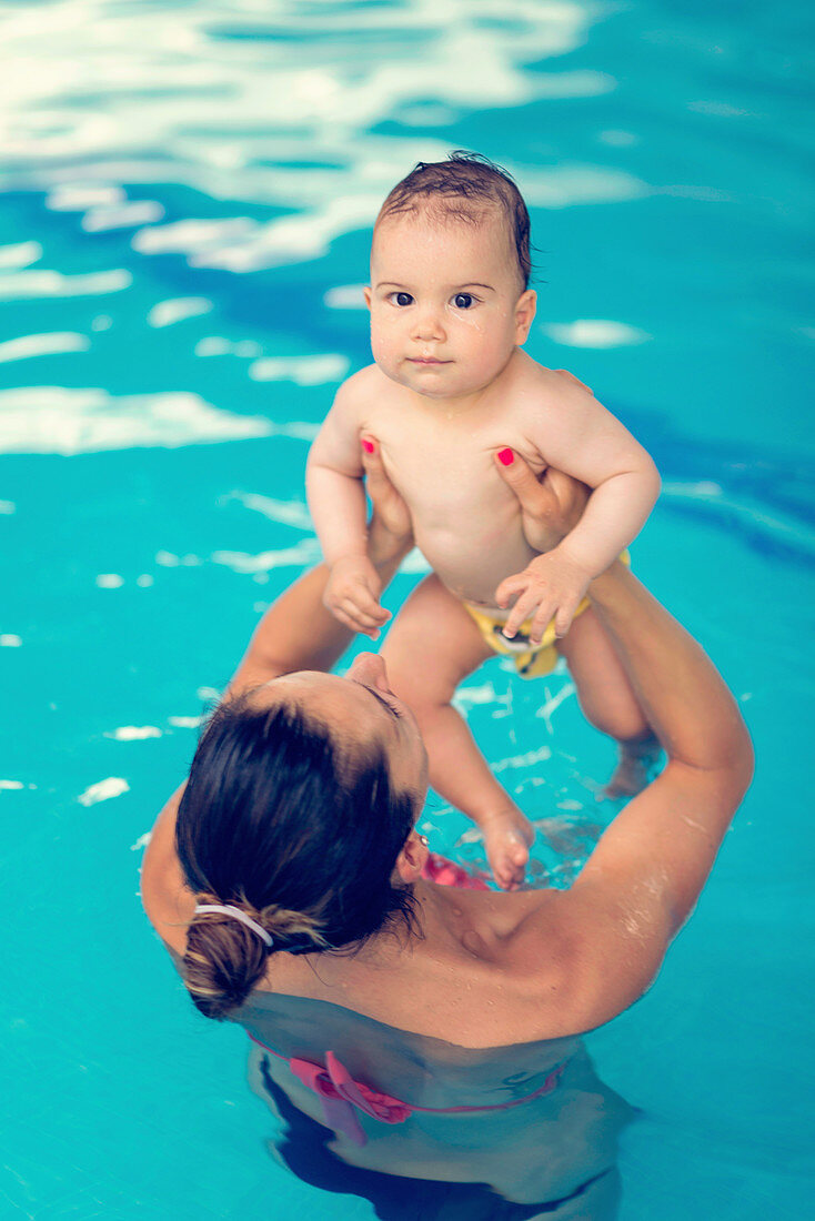 Baby boy and mother in swimming pool
