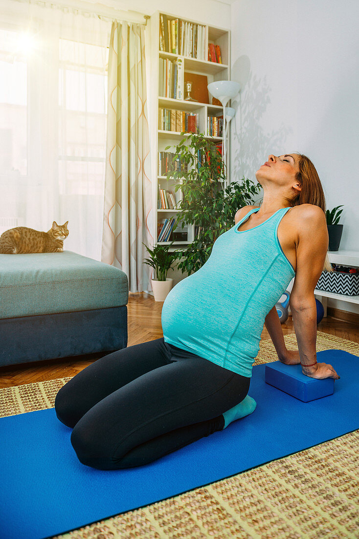 Pregnant woman doing yoga at home