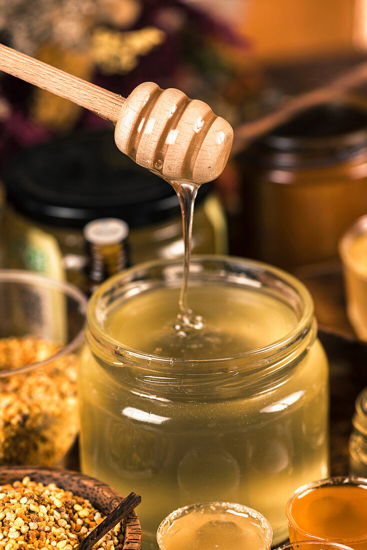 Honey flowing into a glass jar