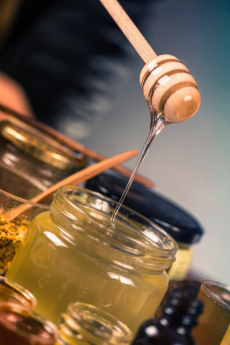 Honey flowing into a glass jar