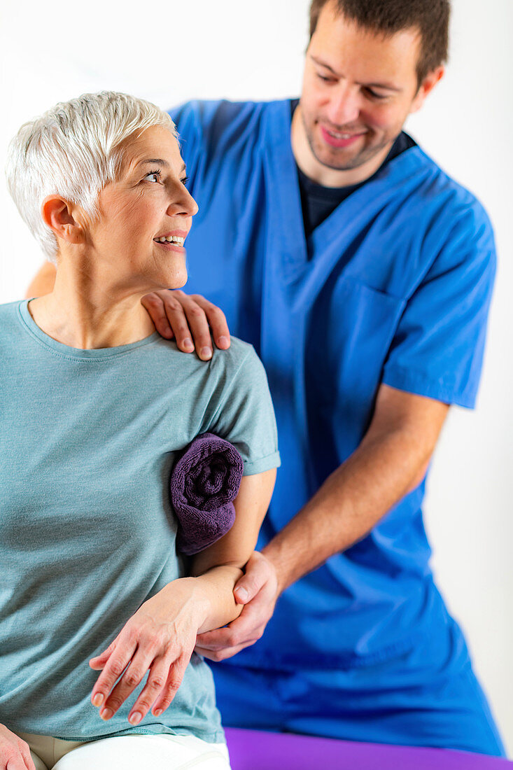 Physical therapist examining patient's arm
