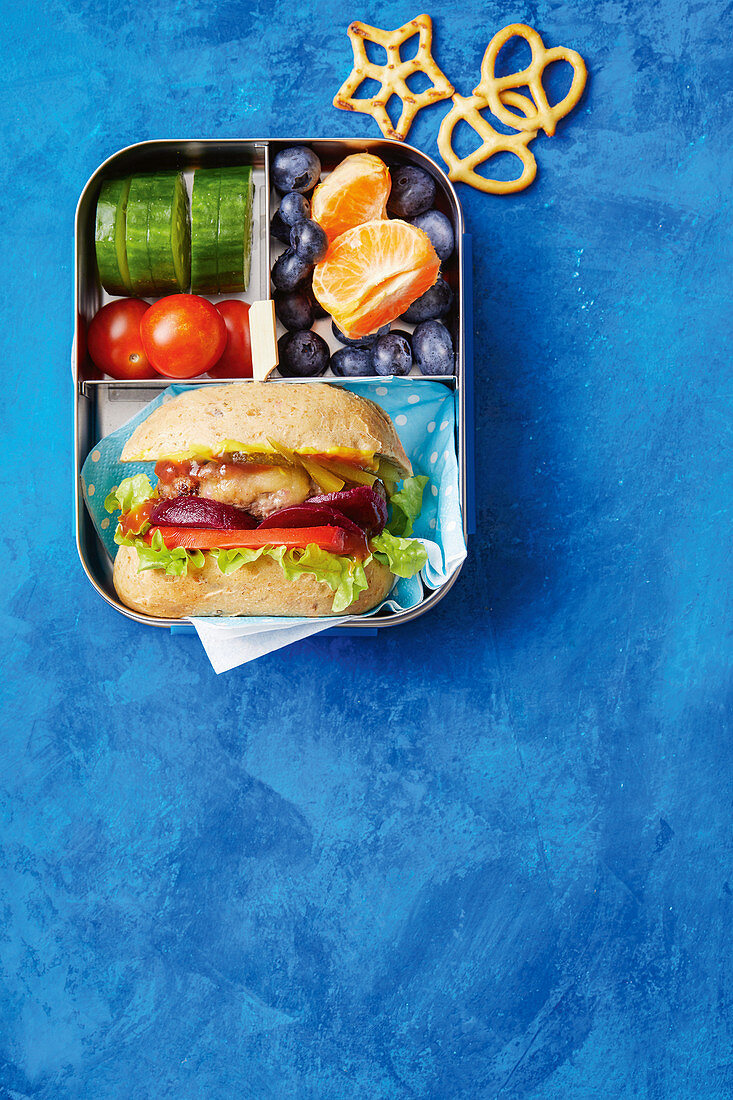 Gesunde Lunchbox mit Gemüse, Obst und Mini Cheeseburger-Sub